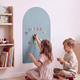 Meisje en jongen spelen met cijfer- en lettermagneten op de MagneetBoog+ in Golfschuim (blauw) bij boekenplank op kinderkamer
