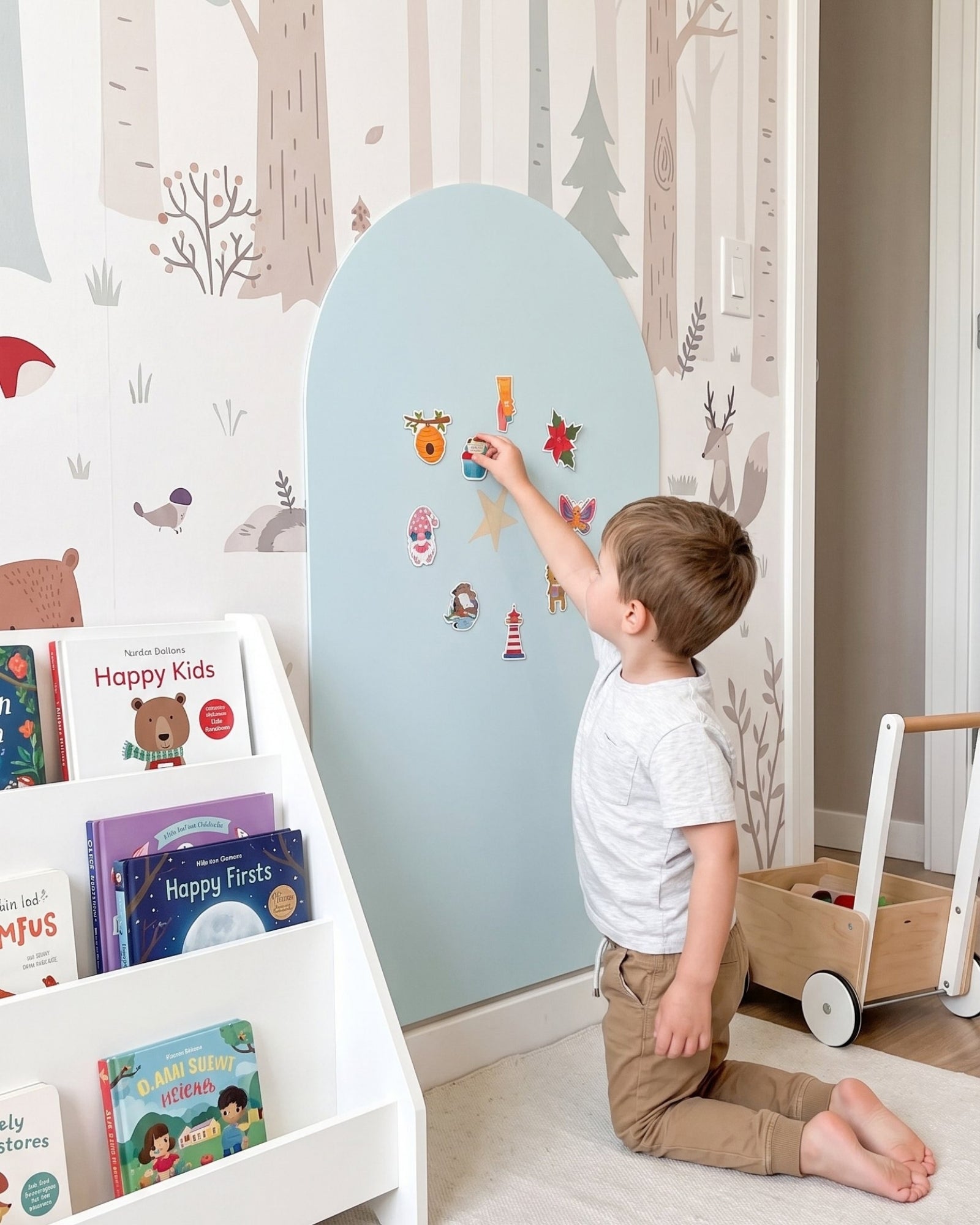Jongen op knieën plaatst magneten op MagneetBoog+ in HimmelDyne (lichtblauw) bij boekenplank op kinderkamer