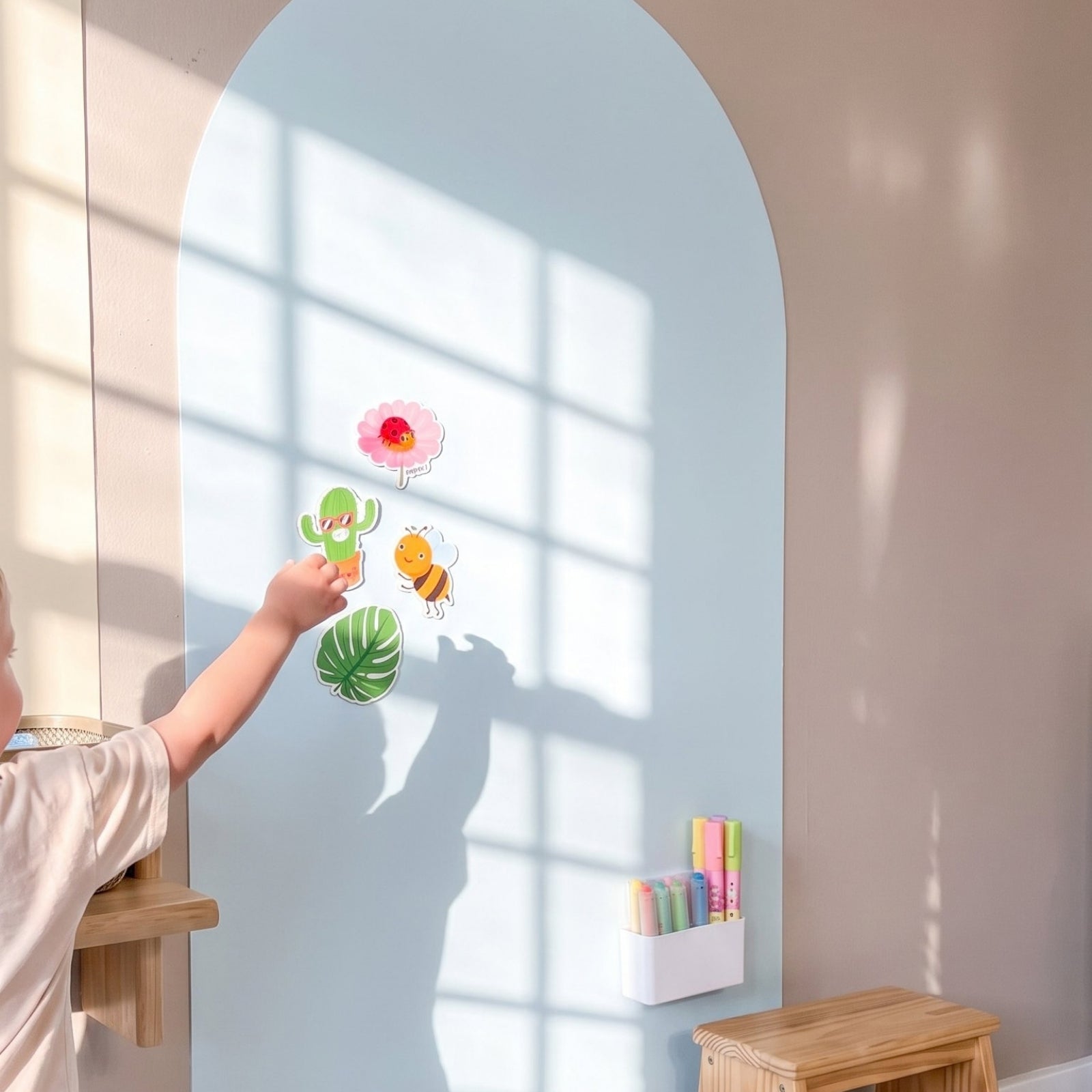 Kind plaatst magneten op de MagneetBoog+ in HimmelDyne (lichtblauw) met magnetische houder voor stiften in zonnig kinderkamer