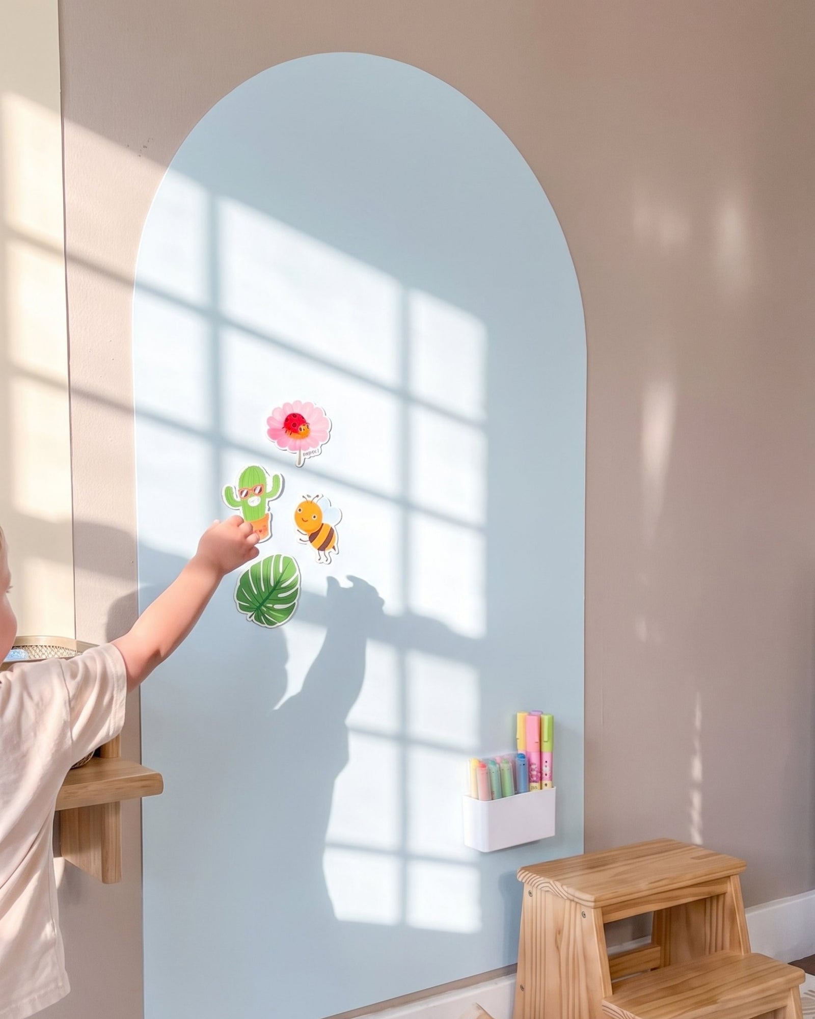Kind plaatst magneten op de MagneetBoog+ in HimmelDyne (lichtblauw) met magnetische houder voor stiften in zonnig kinderkamer