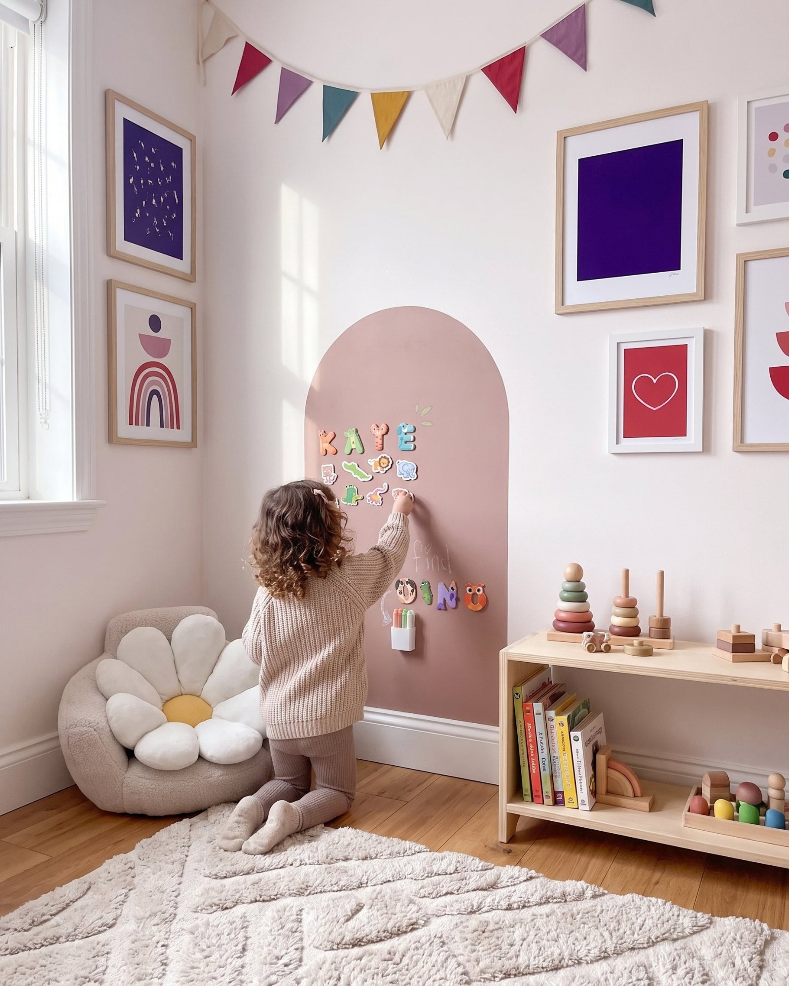 Meisje plaatst dierenmagneten op de MagneetBoog+ in Knuffelkleur (kleibruin) in de hoek van een kleurrijke kinderkamer